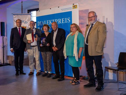 Staatsminister Albert Füracker, Vereinsvorsitzender Claus Ebeling sowie vier Vereinsmitglieder, stellvertretend für die große Zahl an Übersetzerinnen und Übersetzern.
